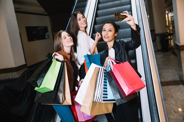 Laughing girls taking selfie in mall