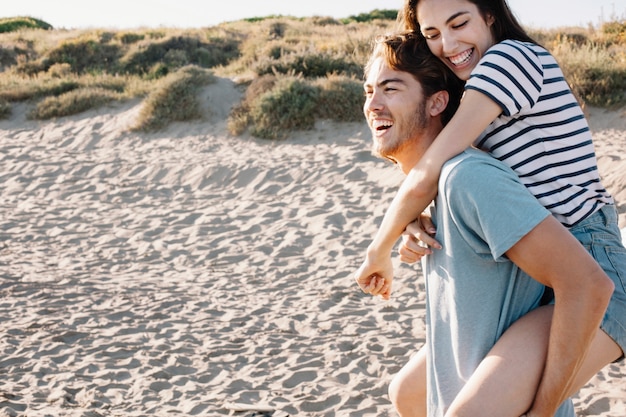 Laughing guy carrying girlfriend