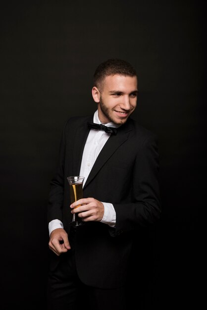 Laughing guy in dinner jacket with glass of drink 