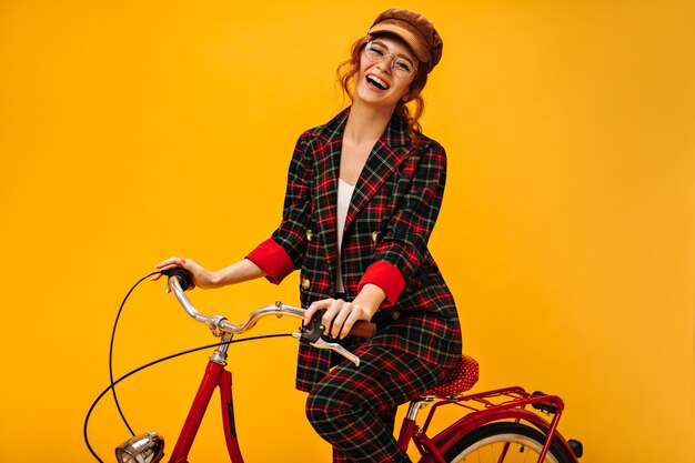 Laughing lady in plaid jacket riding bicycle