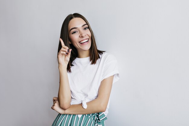 Laughing lady with trendy hairstyle posing. Fascinating female model in white t-shirt having fun