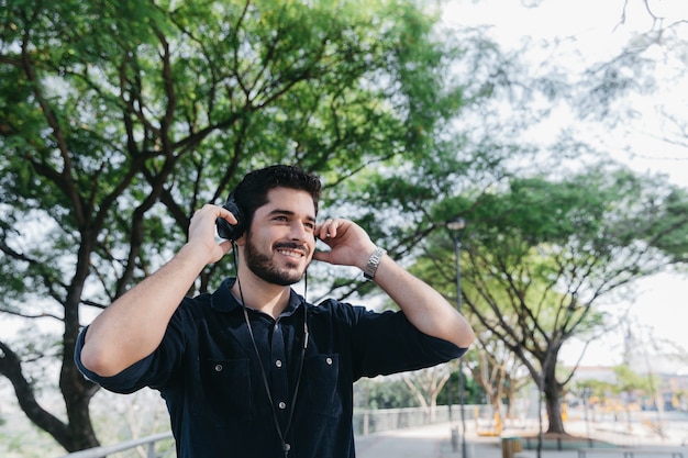 Laughing man enjoying music in earphones