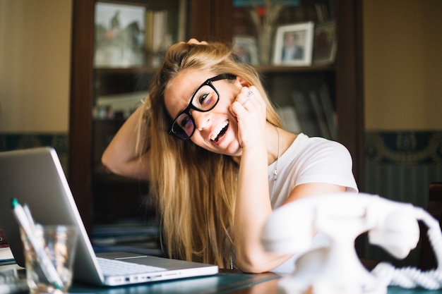 Laughing model watching laptop at home