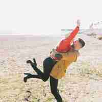 Free photo laughing playful couple on seashore