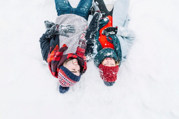 Laughing romantic couple lying in snow