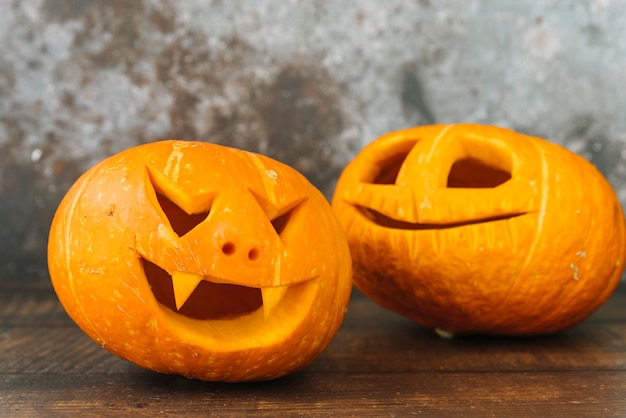 Laughing and smiling carved Halloween pumpkins on desk