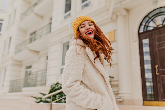 Laughing spectacular woman posing in cold day. Outdoor portrait of attractive girl with bright makeup enjoying winter.