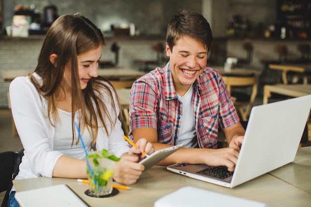 Laughing teenagers with devices