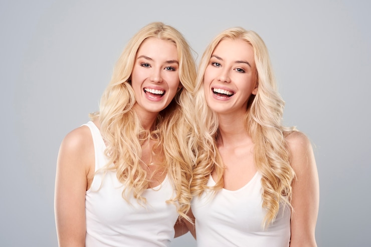 Free Photo laughing twins on the gray background
