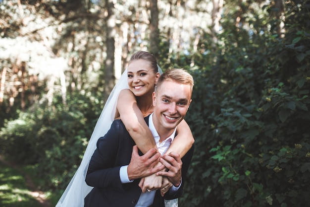 Laughing wedding couple in park