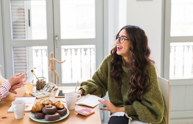 Free photo laughing woman drawing at table