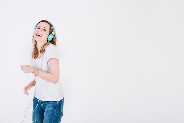 Laughing woman in headphones listening to music