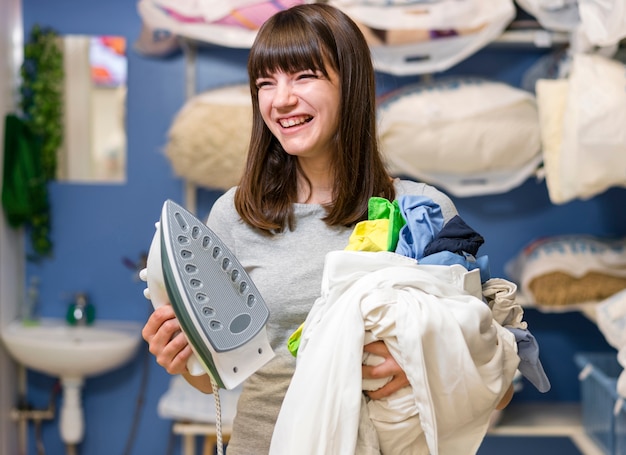 Laughing woman holding clean laundry