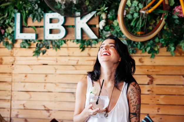 Free photo laughing woman holding cocktail