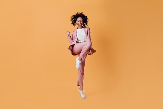 Laughing woman in pink suit showing yes gesture