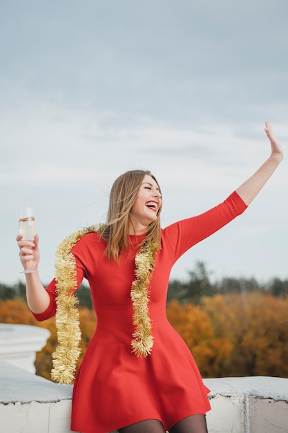 Laughing woman in red dress having fun on the rooftop