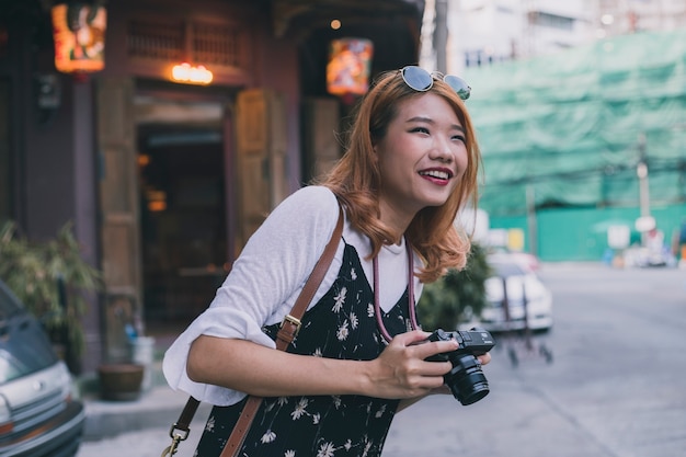 新しい都市を探索するカメラで笑う女性