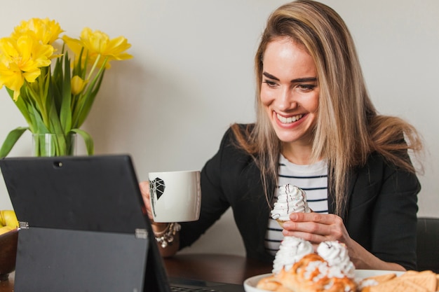 Бесплатное фото Смеясь женщина с кофе и ноутбук