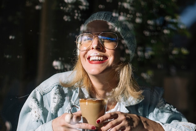 Free photo laughing woman with coffee in cafe