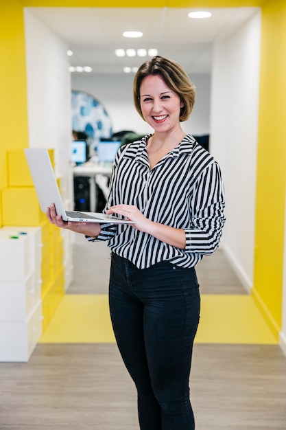 Free photo laughing woman with laptop in office