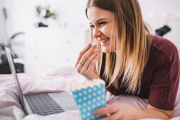 Free photo laughing woman with popcorn watching movie