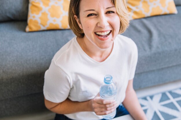 Laughing woman with water looking at camera