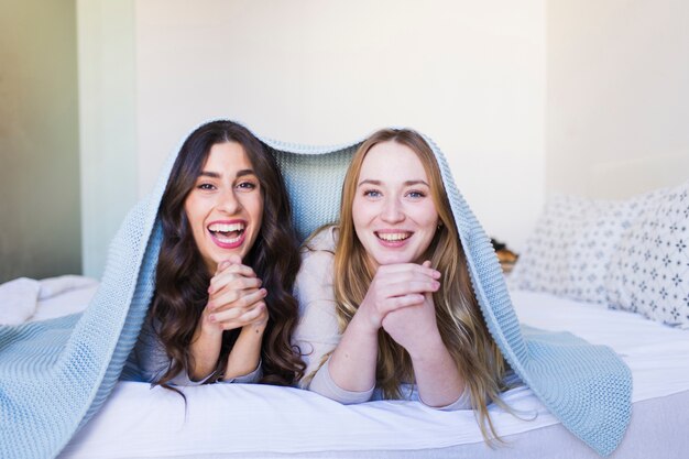 laughing women under blanket