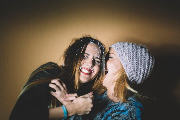 Laughing women covered with artificial snow