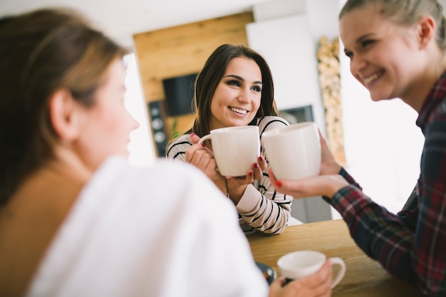 紅茶を楽しみ、話す女性を笑う