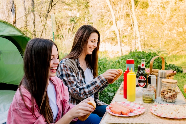 Foto gratuita donne che ridono che fanno hot dog