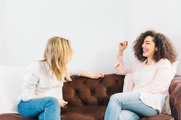 Laughing women speaking on couch