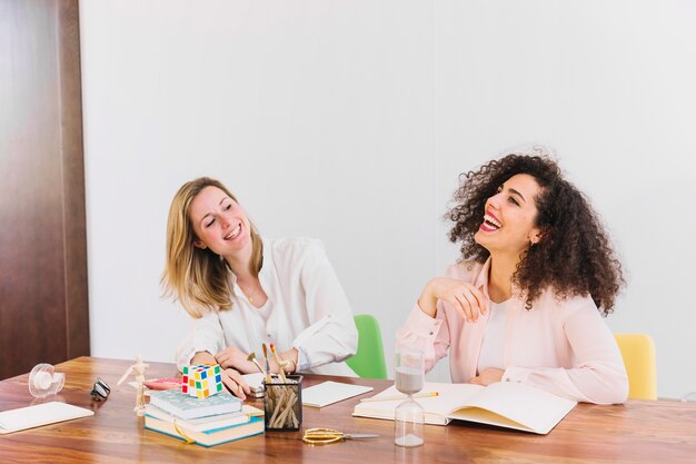 Laughing women studying at table