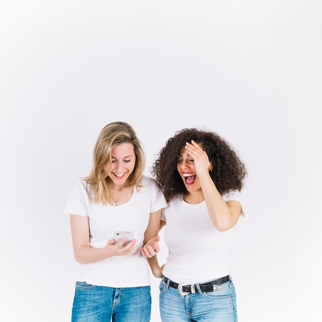 Free photo laughing women using smartphone together