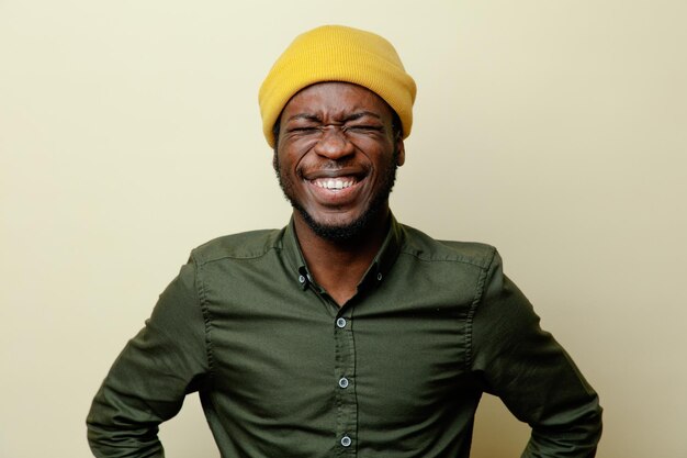 Laughing young african american male in hat wearing green shirt isoloated on white background