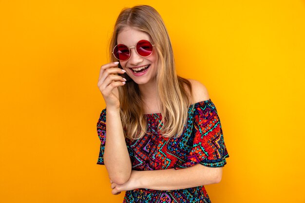 Laughing young blonde slavic girl with sunglasses looking at front