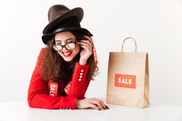 Laughing young caucasian lady near shopping bag