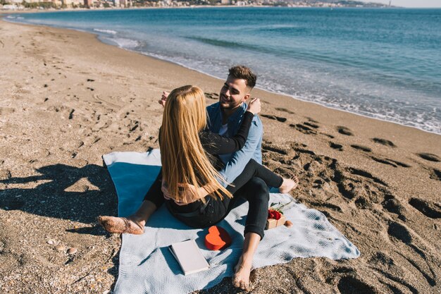 Laughing young couple embracing on shoreline