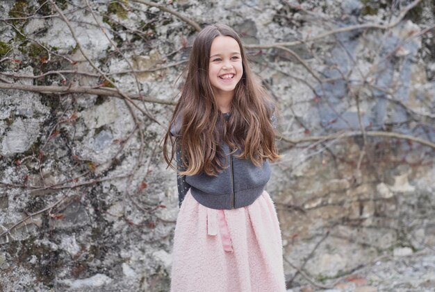 Laughting cute little girl on grey rock background.