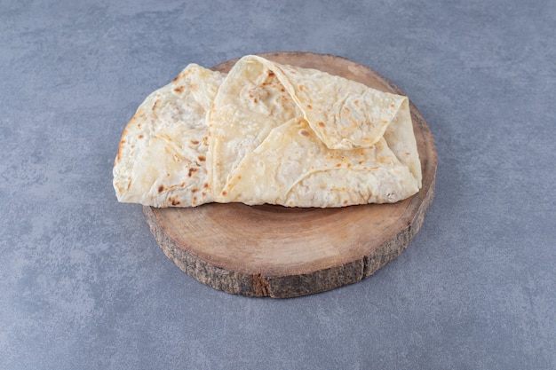 Lavash bread on a board on marble table.