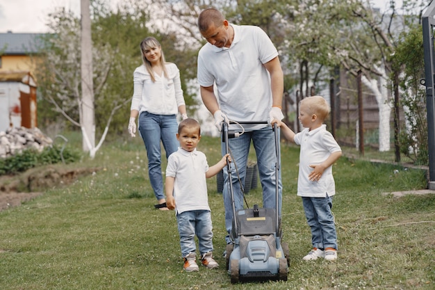 Lawn mower man working on the backyard with sons