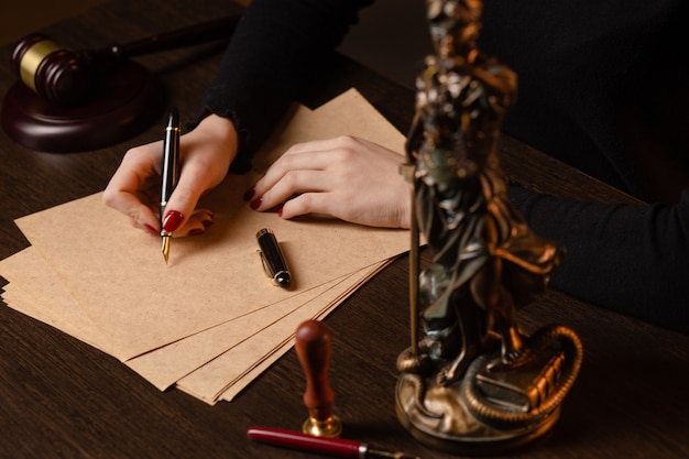 법정 정의 및 법률 변호사 법원 판사에서 tabel에 계약 서류 및 나무 망치로 일하는 변호사