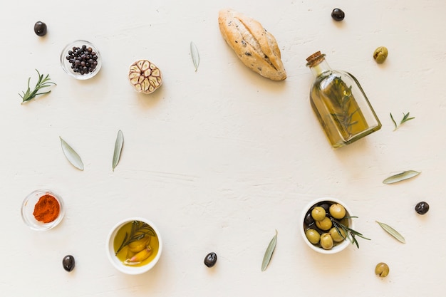 Foto gratuita disposizione delle olive e delle spezie del pane della bottiglia di olio