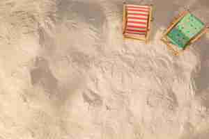 Free photo layout of small decorated deckchairs on sand