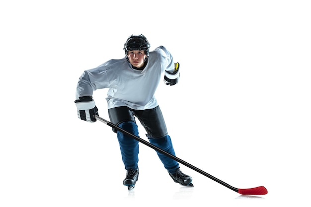 Бесплатное фото Лидер. молодой хоккеист мужского пола с клюшкой на ледовой площадке и белой предпосылке. спортсмен в снаряжении и шлеме тренируется. понятие спорта, здорового образа жизни, движения, движения, действий.