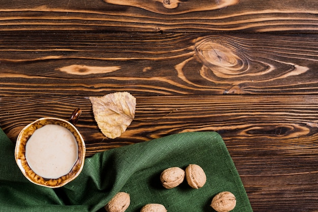 Leaf and beverage near napkin and walnuts