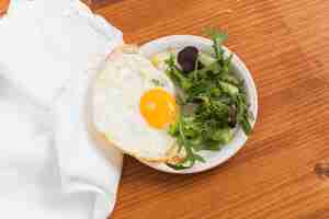 무료 사진 잎이 많은 야채와 나무 책상 위에 접시에 반 달걀 프라이