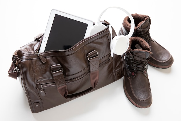 Free photo leather bag packed with shoes and tablet