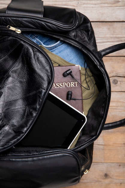 이어폰과 여권이 있는 여행용 가죽 가방