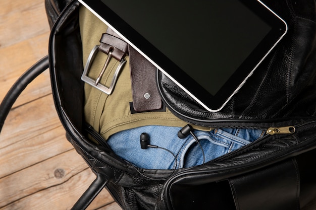 タブレットとイヤホンで旅行するための革のバッグ