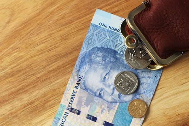 Free photo leather change purse and some change and a banknote on a wooden surface